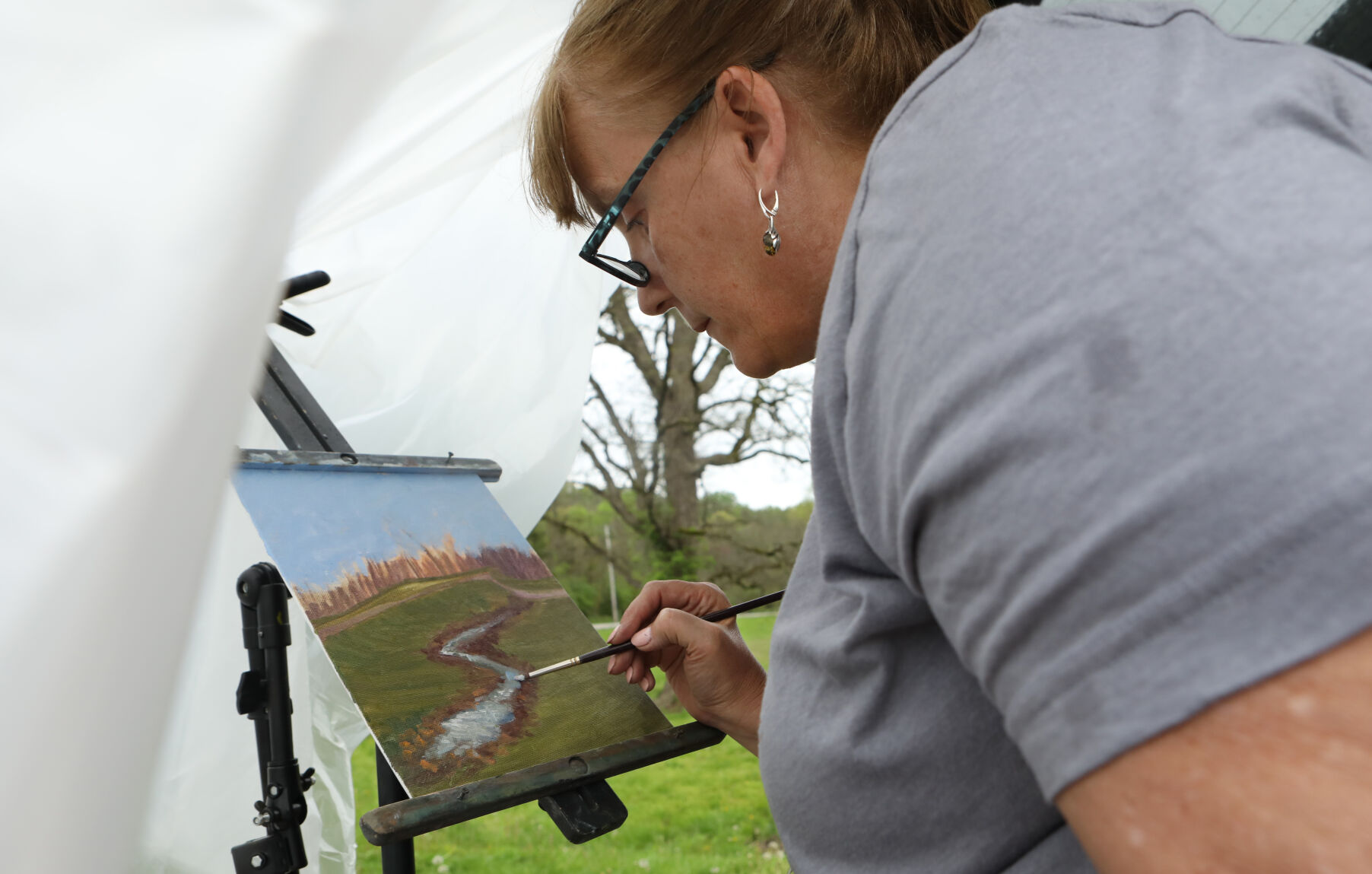 Rhonda pepmiller paints under a tarp